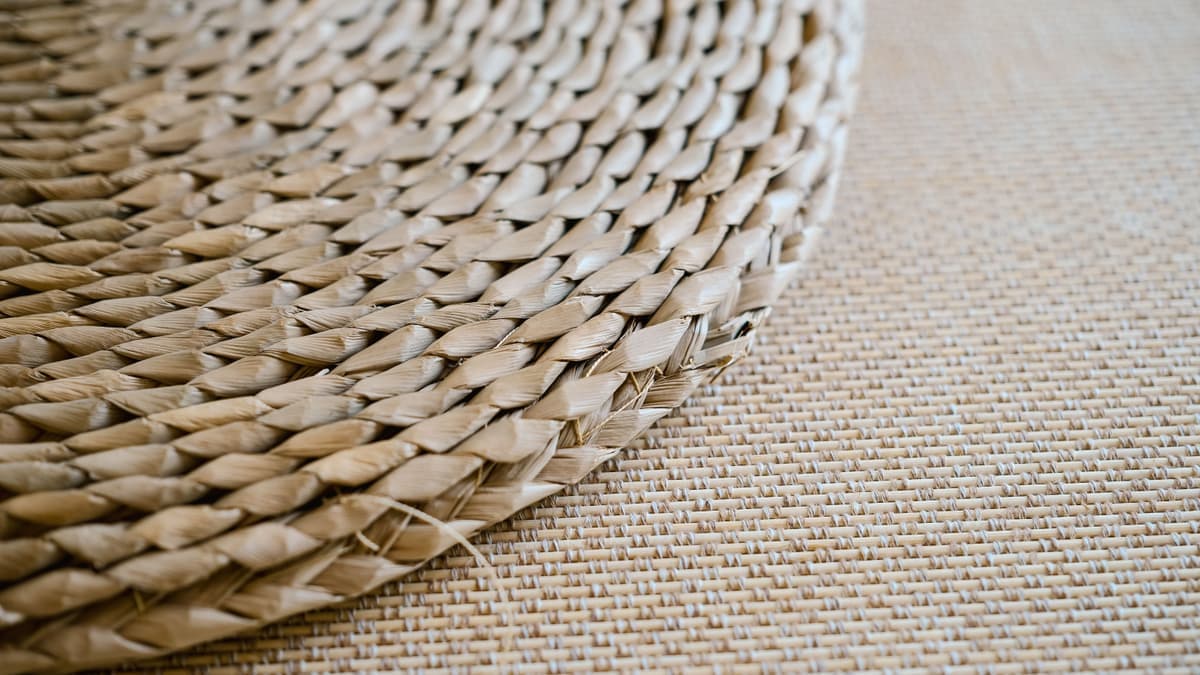 A woven mat laid on beach sand