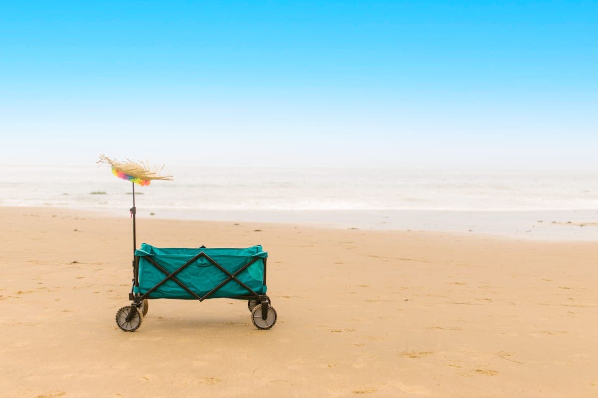 A wagon loaded with gear being pulled on sand